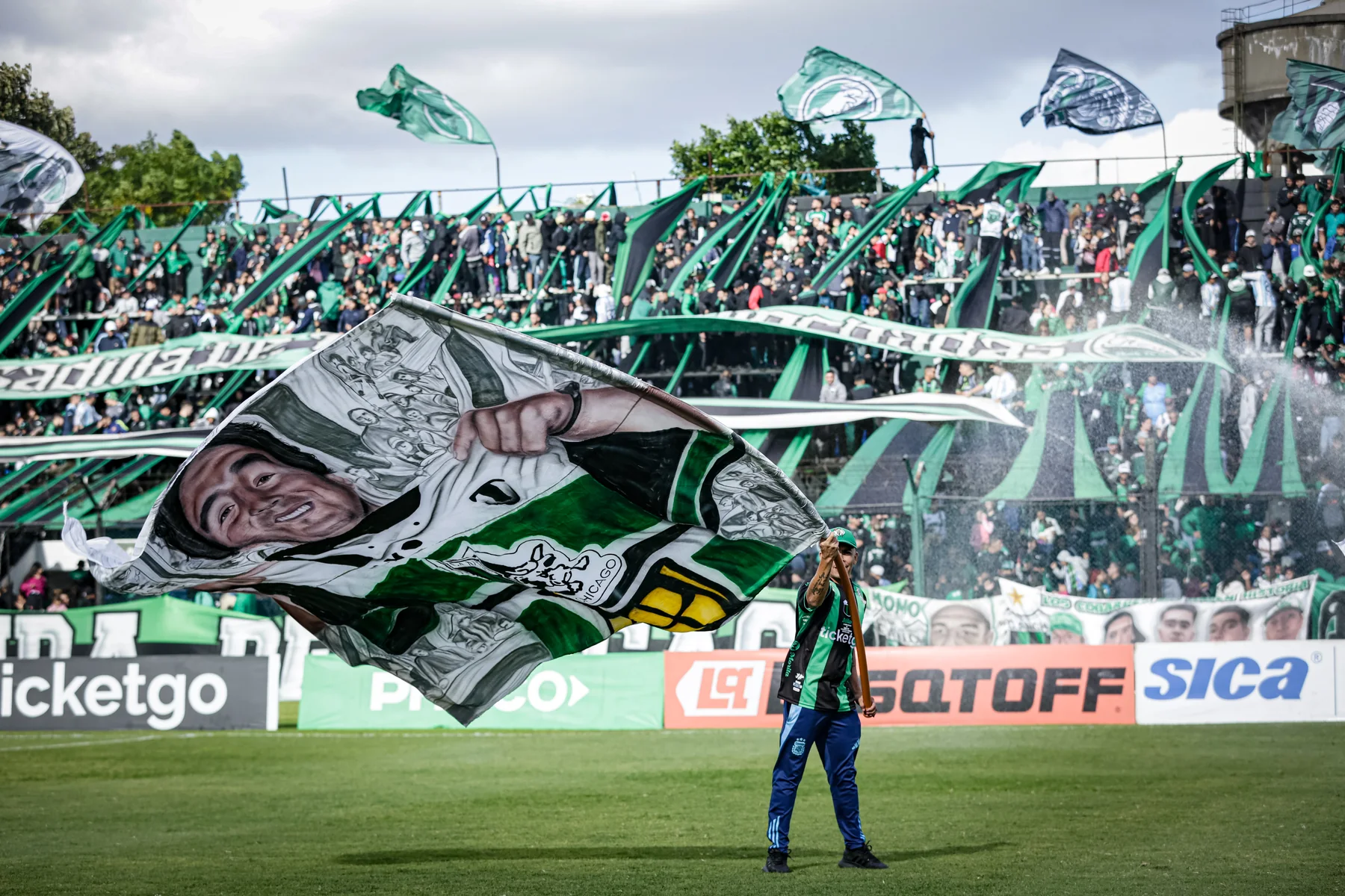 Tribuna de Nueva Chicago con banderas verdinegras
